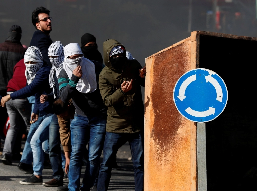 فلسطينيون خلال مواجهات اندلعت مع قوات الاحتلال أمس شمال بلدة بيت حانون (رويترز)
