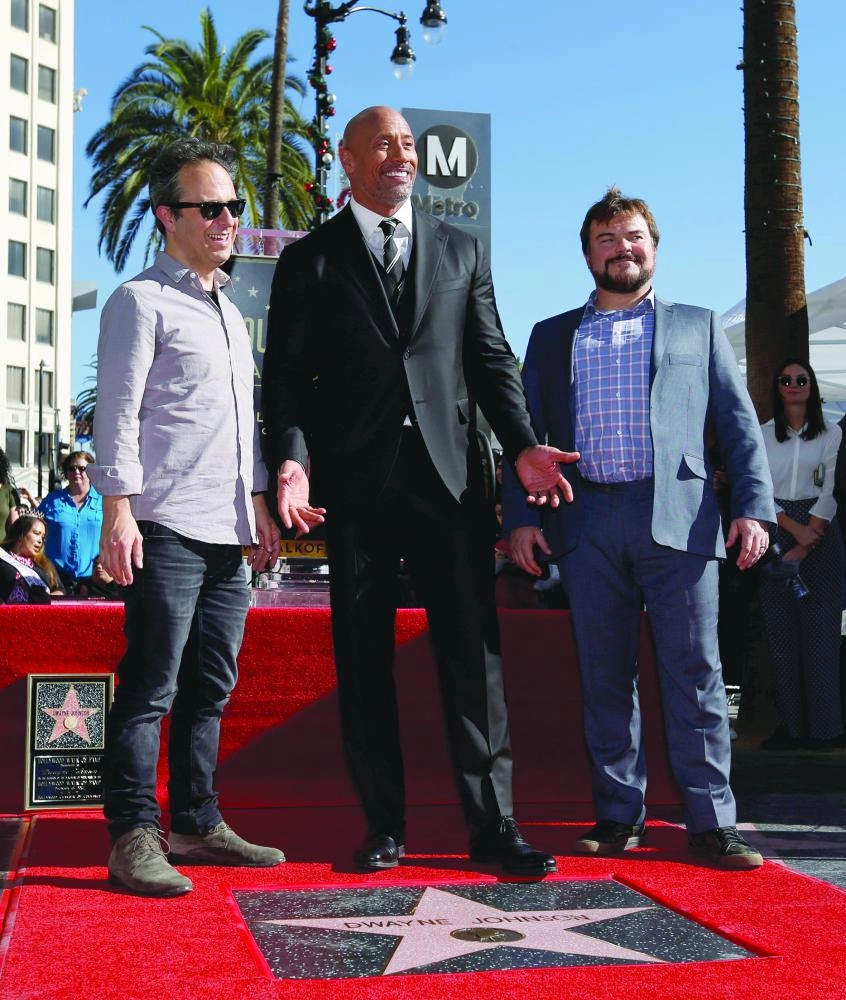 Actor Dwayne Johnson (C) poses on his star with actor Jack Black (R) and director Jake Kasdan after it was unveiled on the Hollywood Walk of Fame in Los Angeles, California, U.S., December 13, 2017. REUTERS/Mario Anzuoni