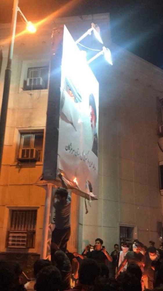 متظاهرون يمزقون صورة خامنئي أمس (تويتر)