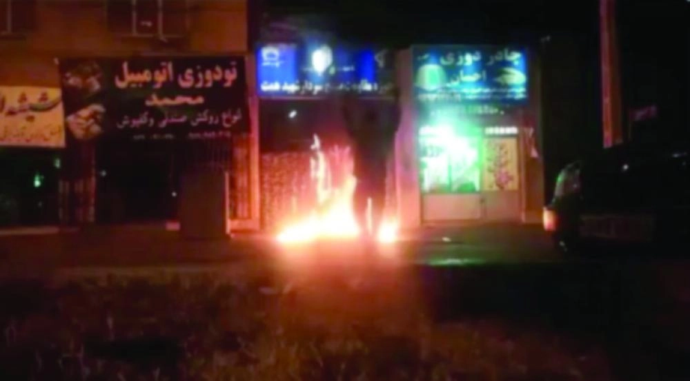 إيراني يوثق حرقه لأحد مقرات الباسيج                                                                 (تويتر)