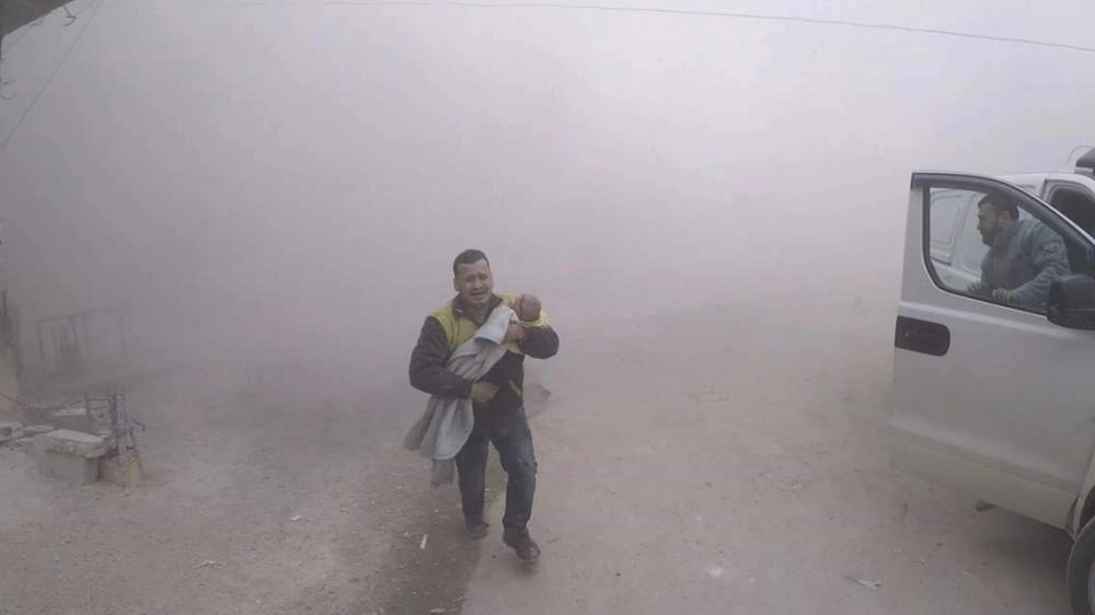 متطوع يحاول إسعاف طفله بعد قصف منزلها في سقبا بغوطة دمشق (تويتر)