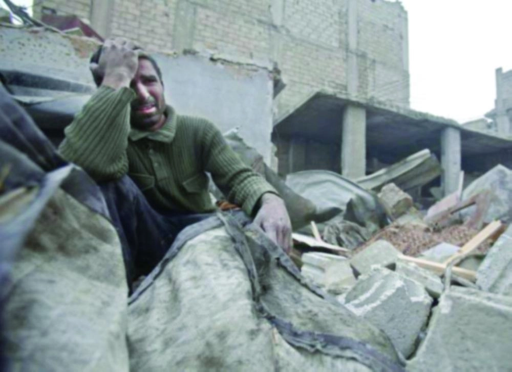 سوري يبكي فوق أنقاض منزله عقب غارة للنظام في الغوطة (تويتر)