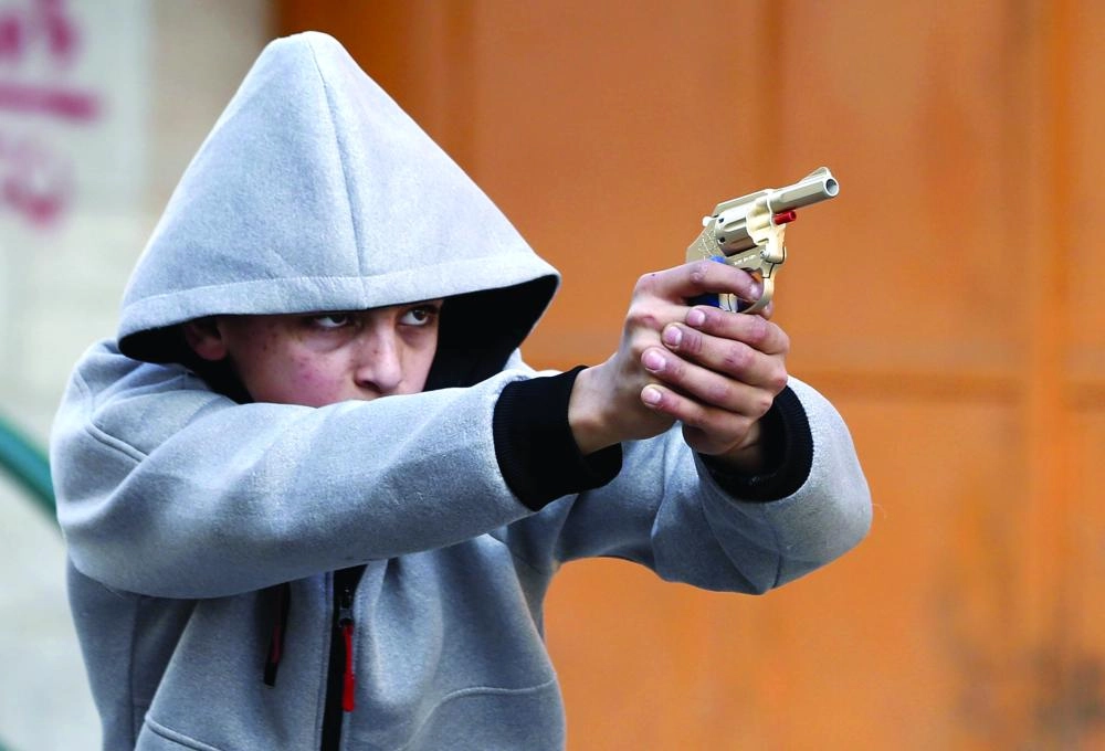 






.. والصبي خلال توجيه سلاحه البلاستيكي باتجاه قوات الاحتلال في الخليل                           (د ب أ)