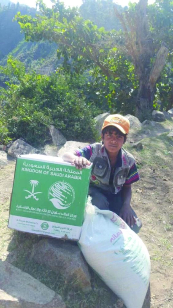 صبي يمني بجوار سلال غذائية سعودية في تعز (واس)