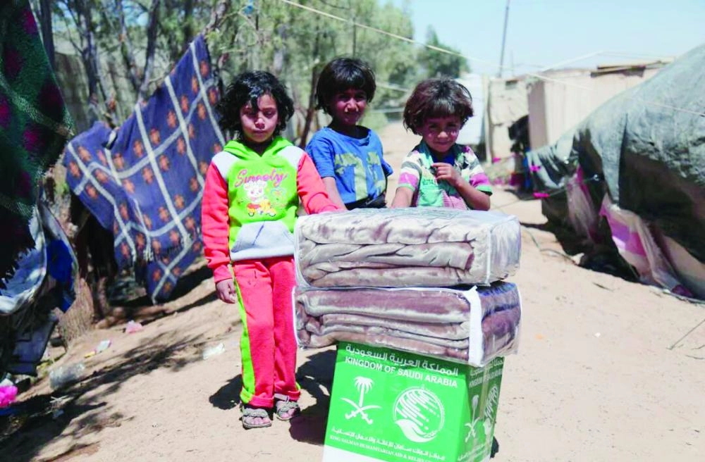 






أطفال يمنيون في مخيم عتمة مأرب بجوار مساعدات سعودية         (واس)