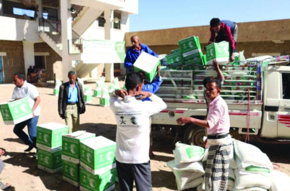 يمنيون يفرغون السلال الغذائية في تعز (واس)