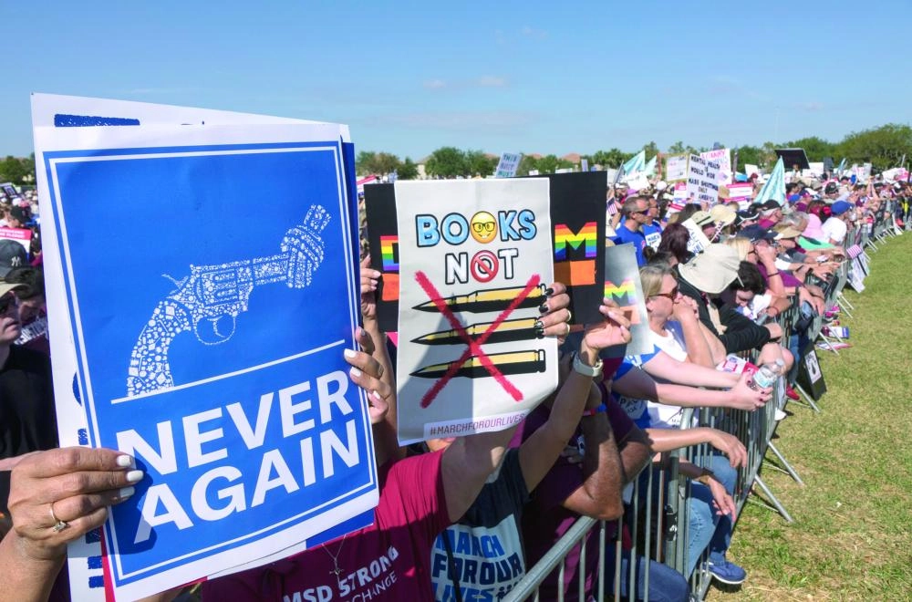 






متظاهرون يحملون لافتات منددة بحمل السلاح                                (إ ب أ)