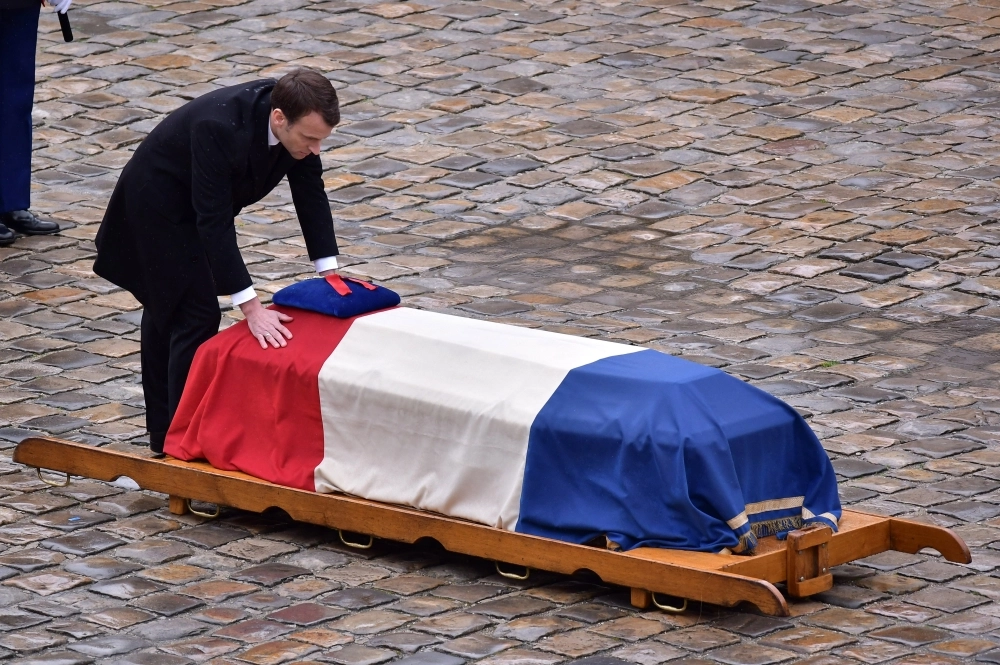 epa06634002 French President Emmanuel Macron stands in front of the flag-draped coffin of the Gendarme Lieutenant-Colonel  Arnaud Beltrame during a solemn funeral ceremony, in the courtyard of the Invalides in Paris, France, 28 March 2018. Beltrame was killed after swapping himself in exchange of a female hostage during a terrorist attack in Trebes, southern France, on 23 March 2018.  EPA/CHRISTOPHE PETIT TESSON