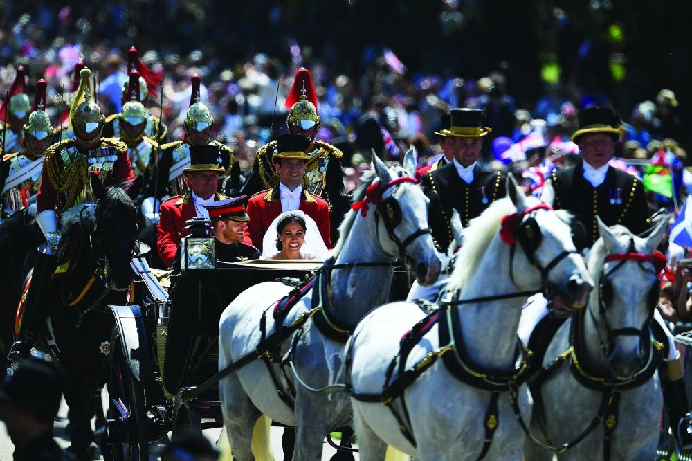 dpatop - Prince Harry and Meghan Markle ride in an open-topped carriage through Windsor Castle after their wedding at St George's Chapel, in Windsor, England, 19 May 2018. Photo: Jeff J Mitchell/PA Wire/dpa