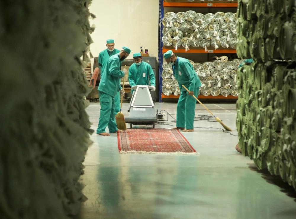 المرحلة الخامسة في غسل السجاد وهي الكنس والرش بالمعطرات قبل الطي والتغليف