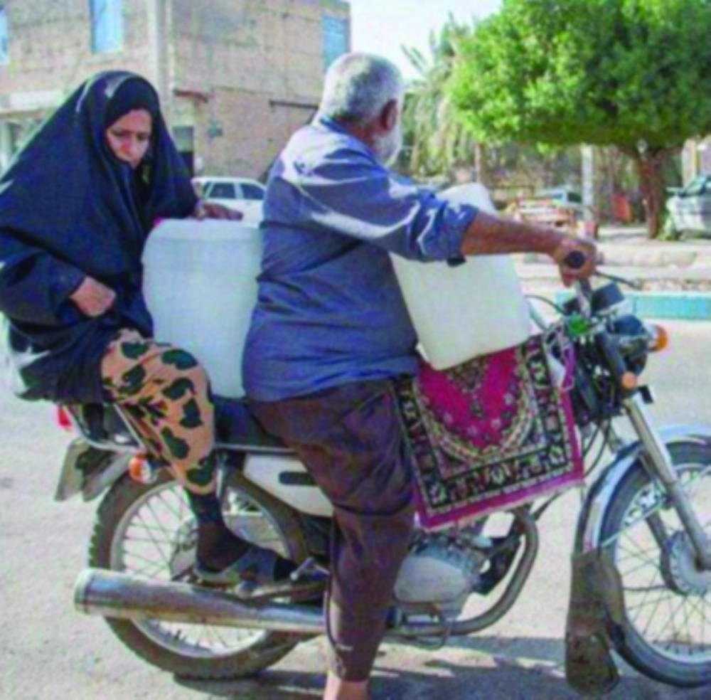 






مسنان إيرانيان خلال رحلة تأمينهما للماء                                              (تويتر)