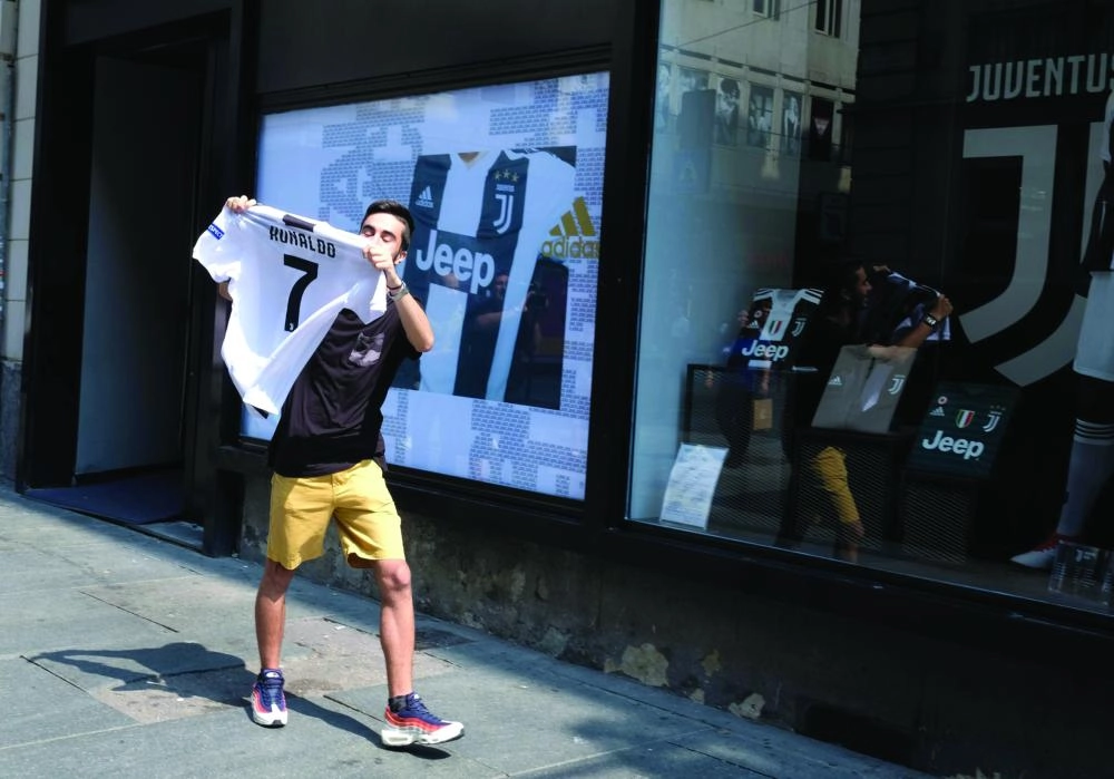 






مشجع يستعرض قميص رونالدو عقب شرائه              (إ ب أ)