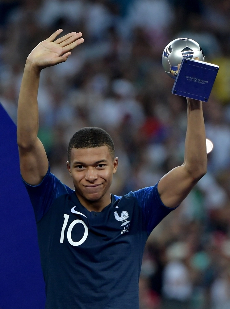 مبابي محتفلا بجائزة أفضل لاعب شاب في المونديال (إ ب أ)