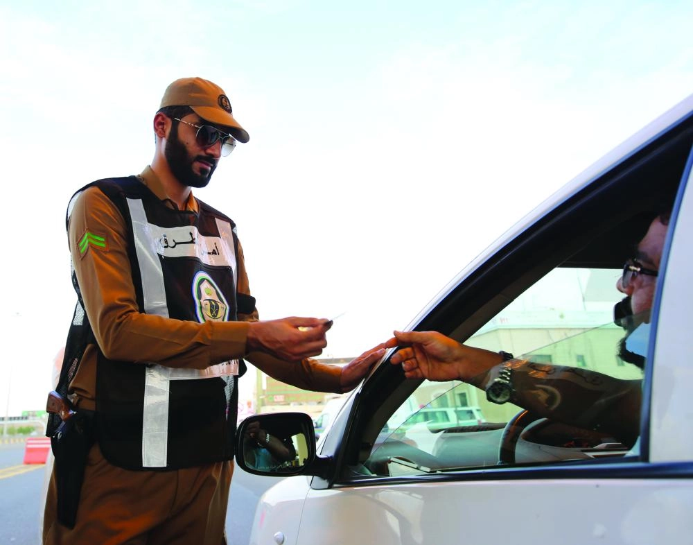 رجل أمن خلال التأكد من هوية قائد إحدى المركبات