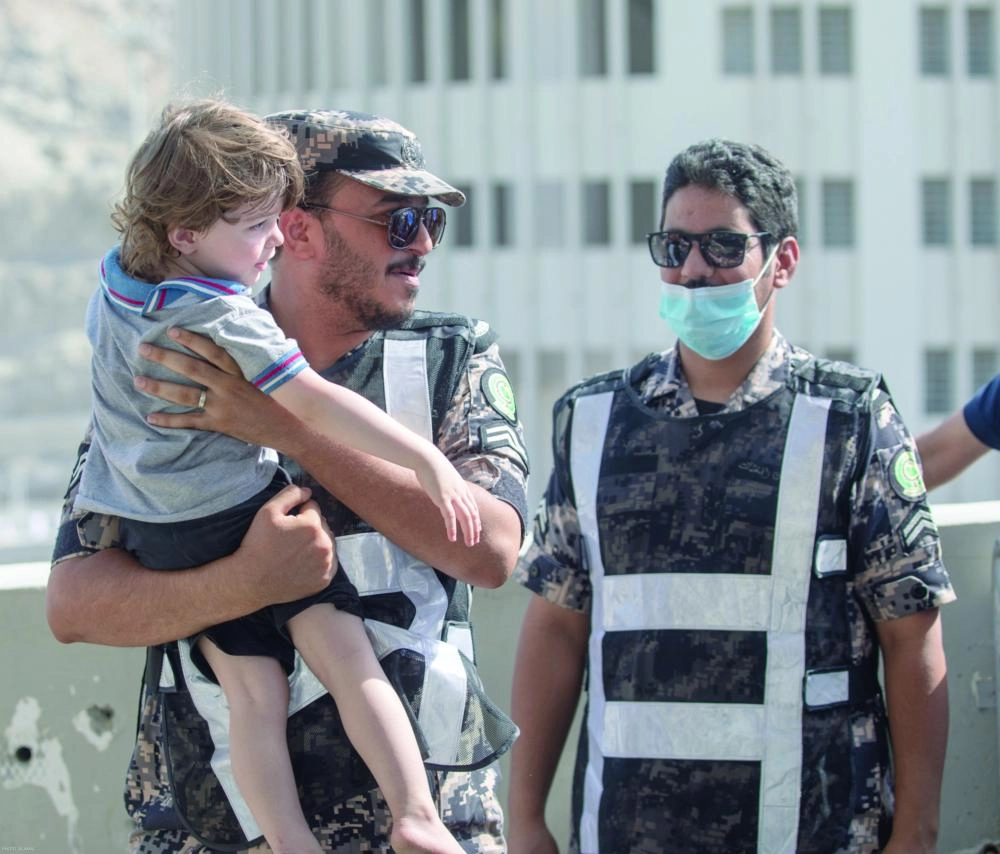 رجل أمن يحمل طفلا بمنشأة الجمرات    (ياسر بخش)