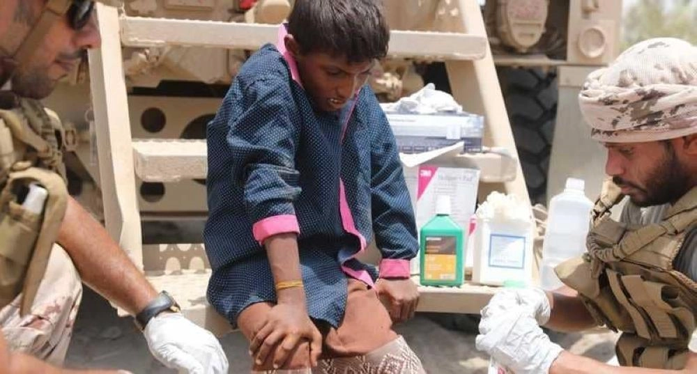 أفراد التحالف خلال معالجة طفل يمني تأثر من الصاروخ الإيراني (مكة)