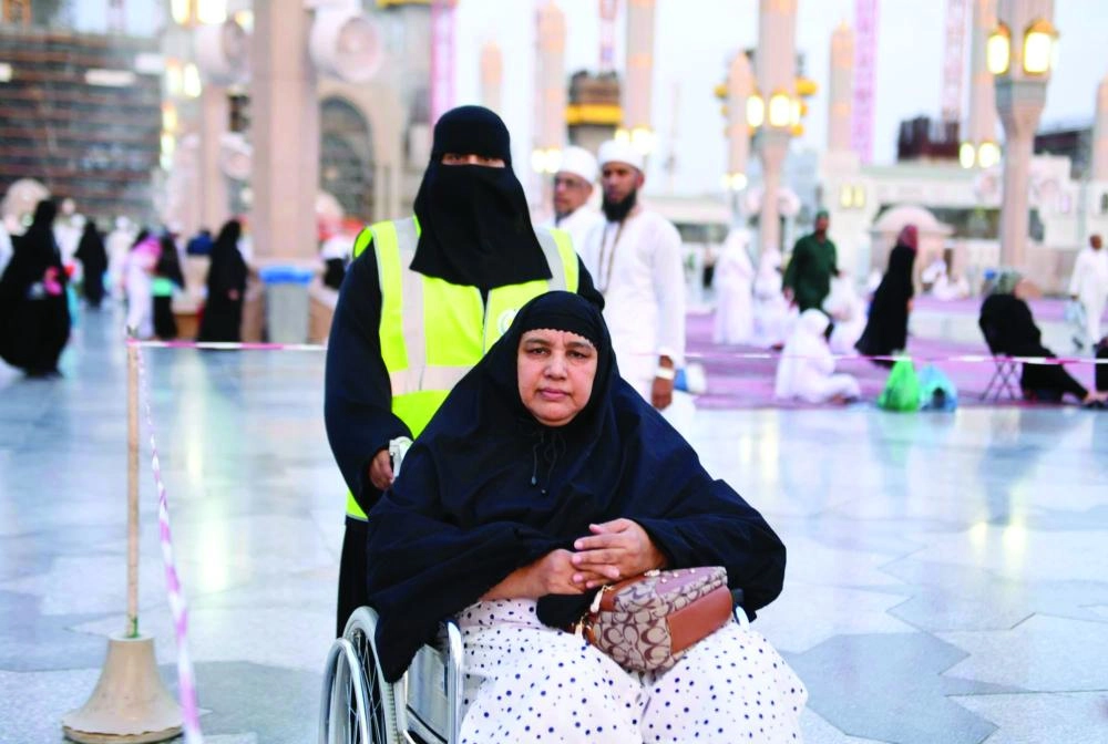 






متطوعة تدفع عربة حاجة                    (واس)