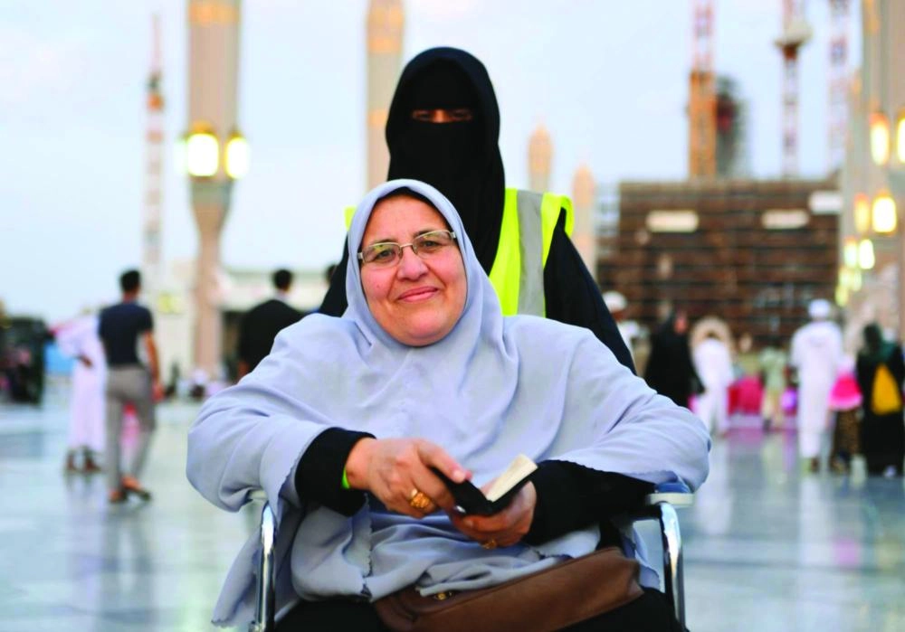 إحدى المتطوعات تدفع عربة حاجة (واس) 