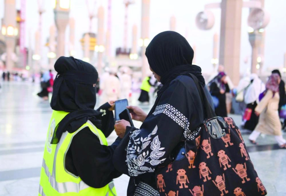 متطوعة تساعد إحدى الحاجات للوصول إلى وجهتها (واس)