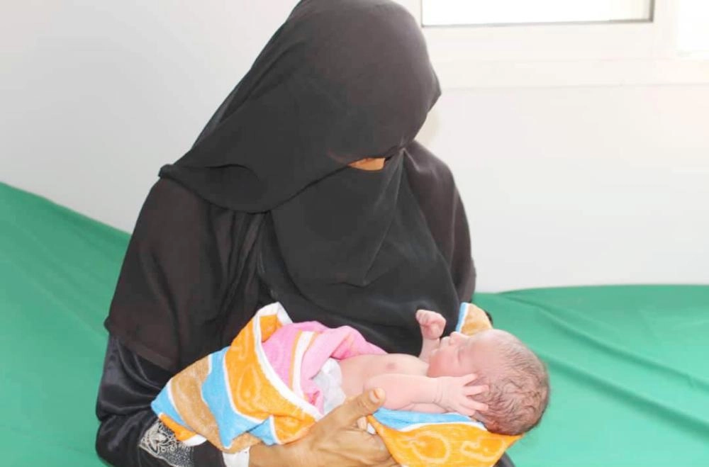 الطفلة وفاء في حضن أمها بعد ولادتها في العيادات المتنقلة لمركز الملك سلمان (واس)