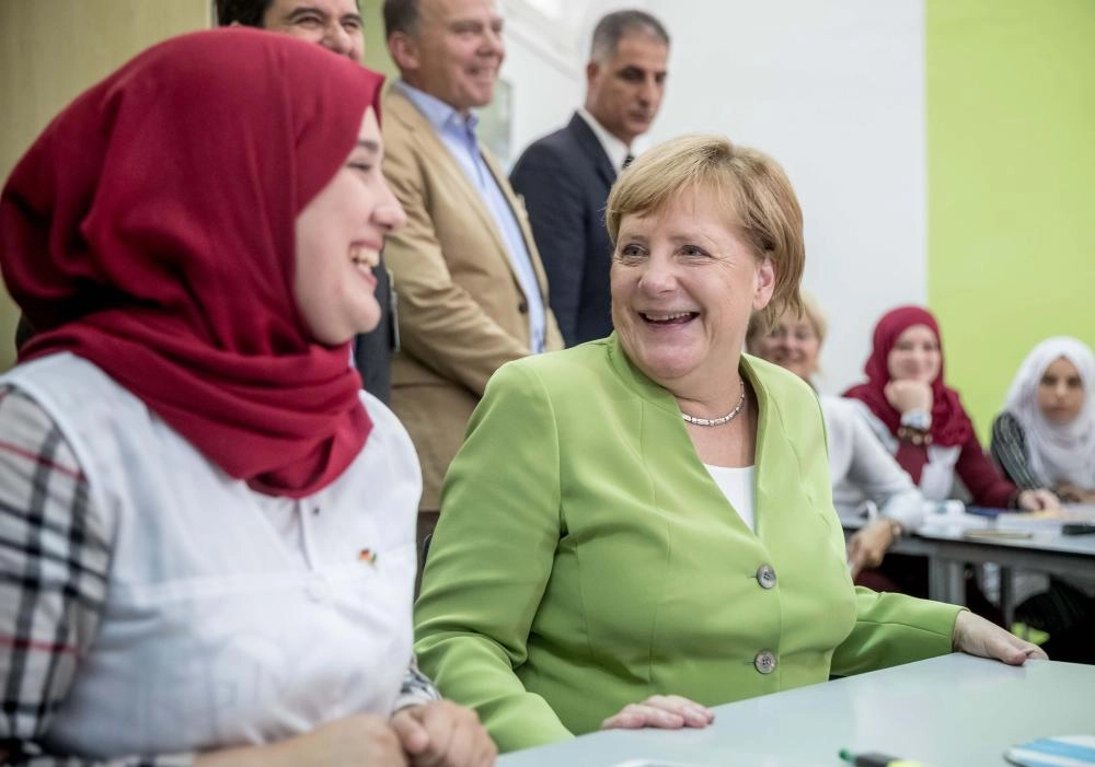 أنجيلا ميركل تتحدث إلى الطلاب خلال زيارتها المدرسة (د ب أ)