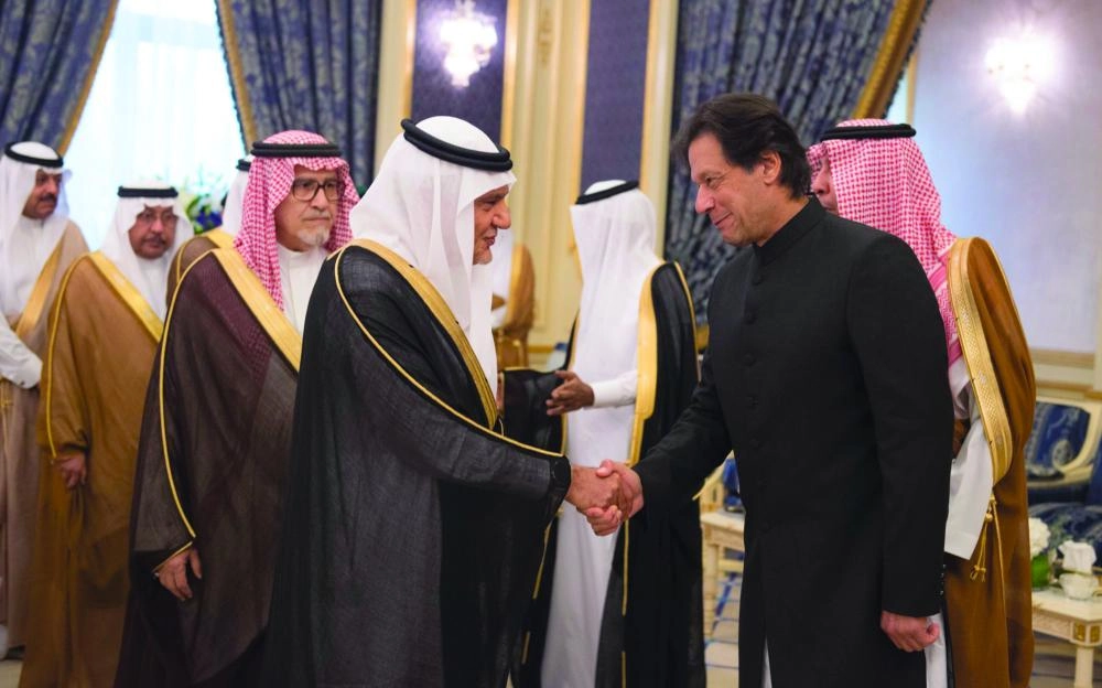 عمران خان مصافحا تركي الفيصل خلال الاستقبال 