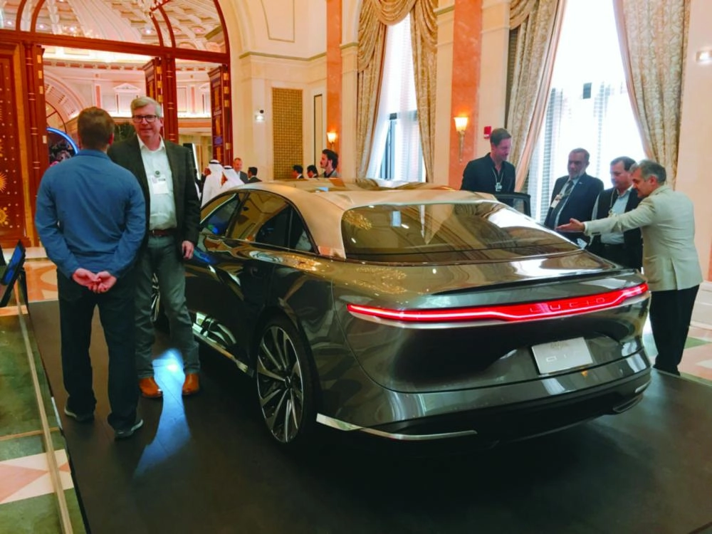 زوار بجانب سيارة لوسيد إير