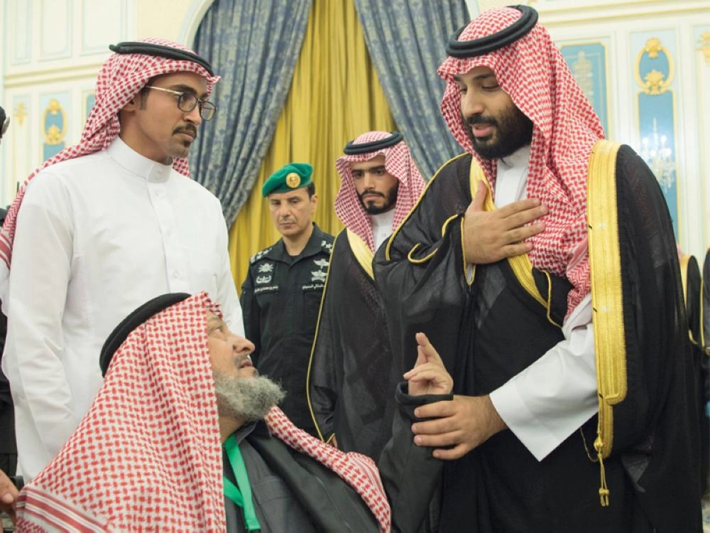 ولي العهد الأمير محمد بن سلمان لدى لقائه عددا من أسر شهداء الواجب في الديوان الملكي (واس)