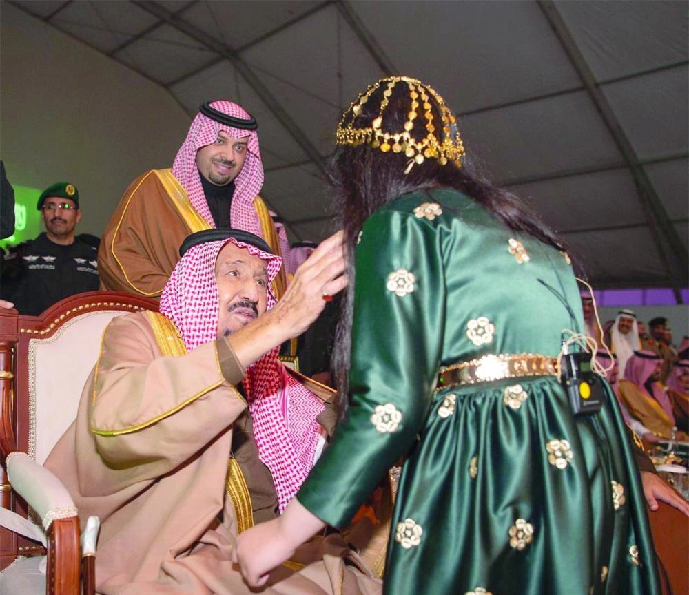 الملك سلمان مع طفلة شاركت بقصيدة في الحفل