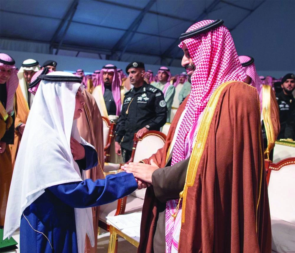 ولي العهد مع أحد الطلاب المشاركين في حفل الأهالي