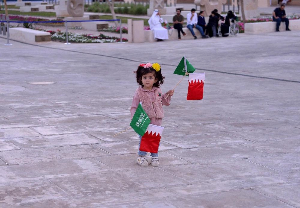 طفلة تحمل علمي السعودية والبحرين في فعاليات مركز إثراء (واس)