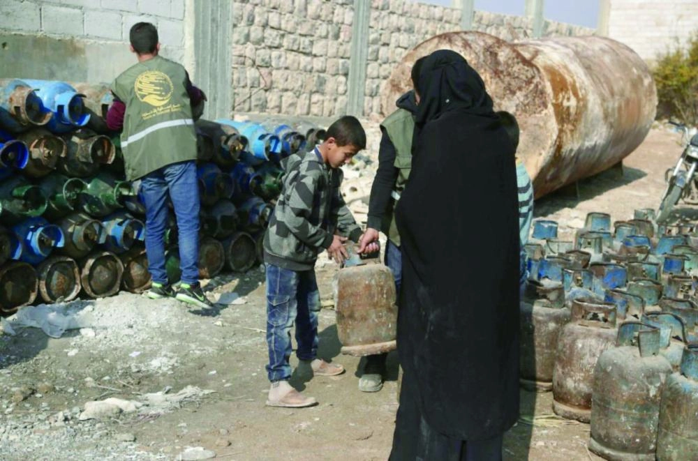 






سوريون خلال تسلمهم اسطوانات الغاز          (واس)