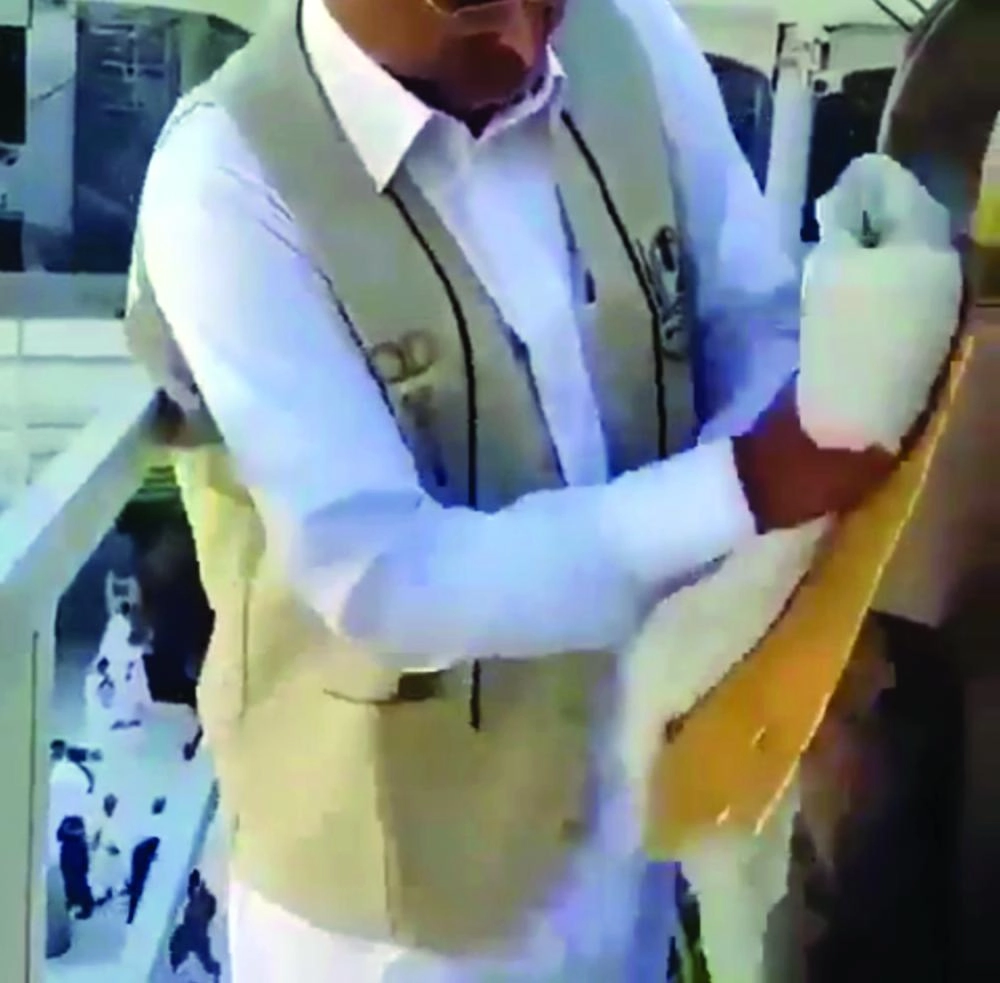 موظف إدارة التطهير والسجاد خلال تنظيف الميزاب (مكة)