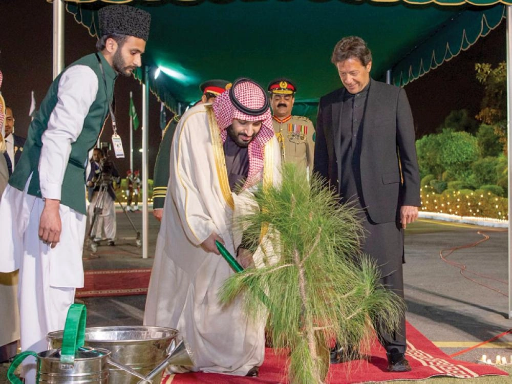 الأمير محمد بن سلمان يروي شتلة لدى وصوله إلى إسلام أباد أمس وبرفقته رئيس وزراء باكستان (واس)