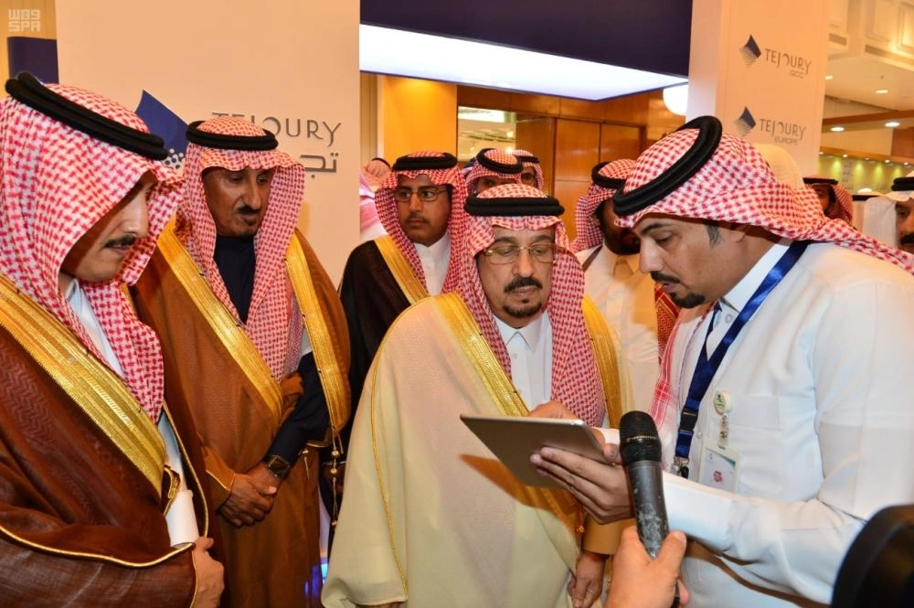 أمير الرياض مستمعا إلى شرح من أحد المشاركين في المؤتمر (واس)