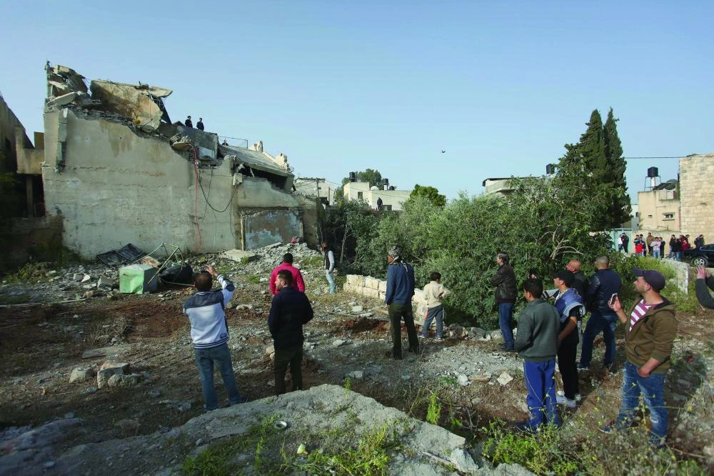 






فلسطينيون يقفون بالقرب من منزل عائلة عمر أبوليلى بعد هدمه             (د ب أ)