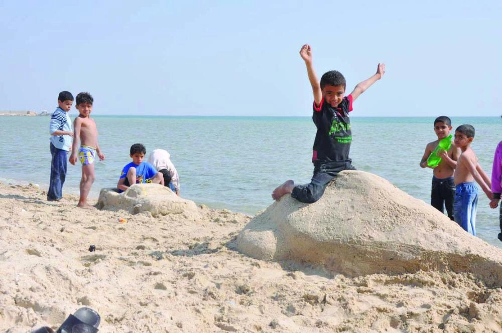 أطفال يستمتعون بشاطئ العقير الرملي