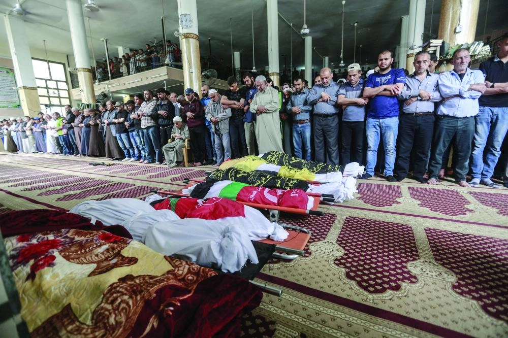 






الفلسطينيون يؤدون الصلاة على عدد من الشهداء                    (د ب أ)