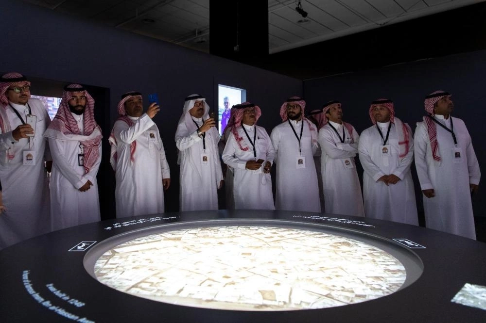 فنانو الرياض خلال زيارتهم معرض "مدن دمرها الإرهاب" (مكة)