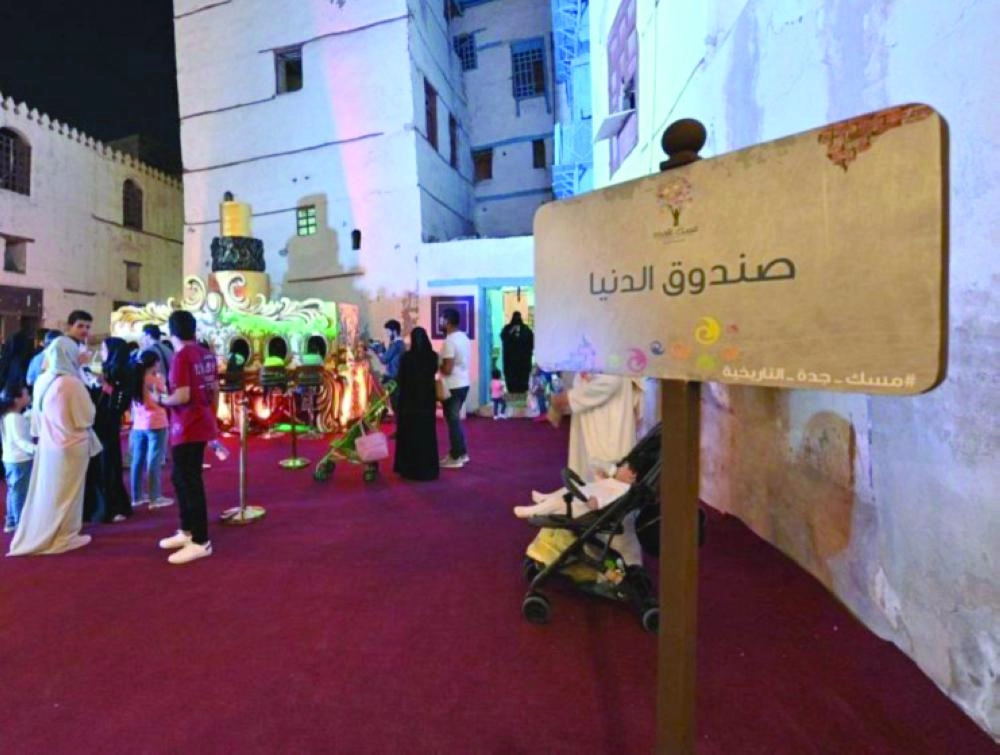 عدد من الزوار خلال اطلاعهم على صندوق الدنيا (مكة) 