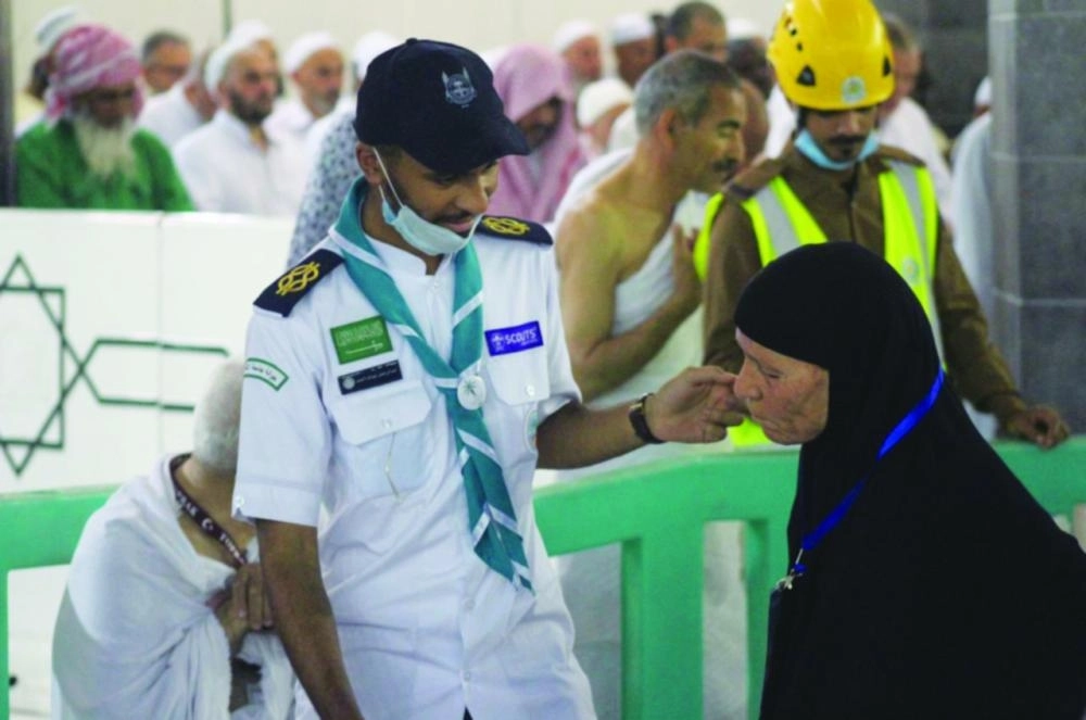 أحد أفراد الكشافة يساعد مسنة بالمسجد الحرام  (مكة)