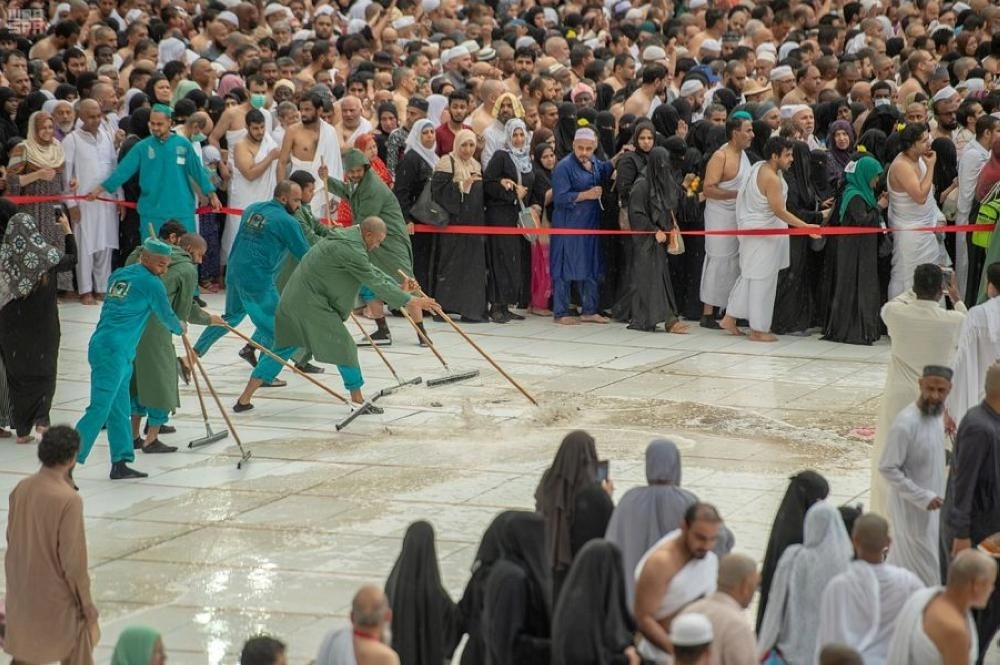العاملين في المسجد الحرام خلال عملية نظافة صحن المطاف من الأمطار ( مكة ) 