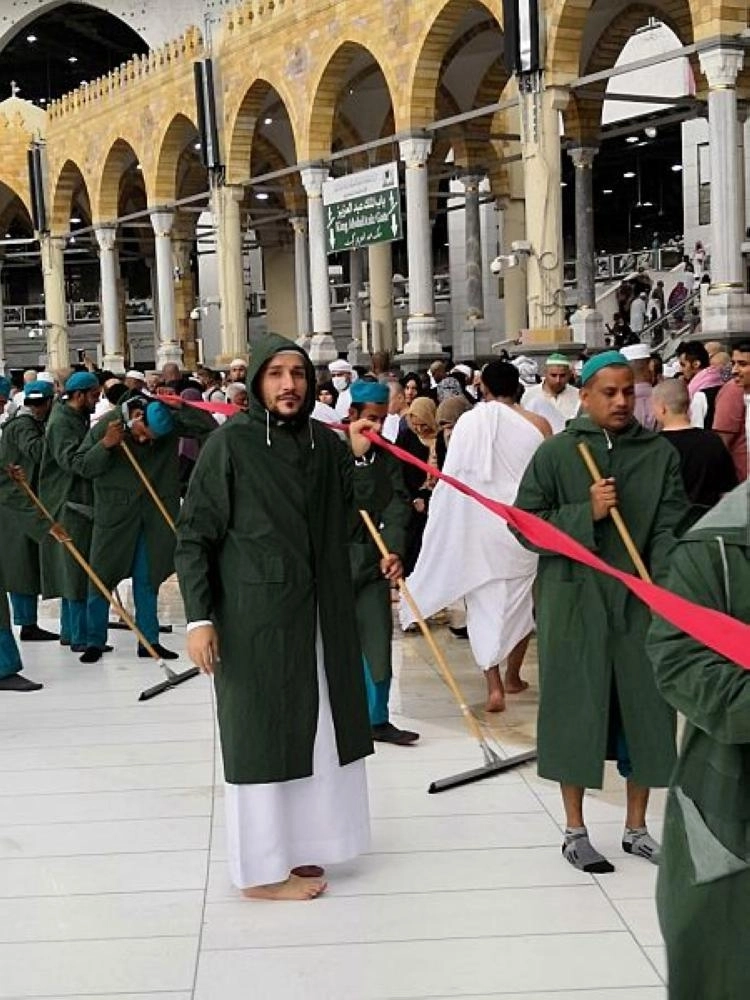 عمال أثناء إزالة مياه الأمطار بالمسجد الحرام (واس)