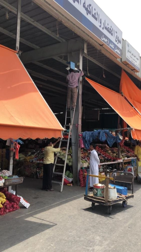 عمال يتفقدون كفاءة إحدى الكاميرات الـ10 أمس (مكة)