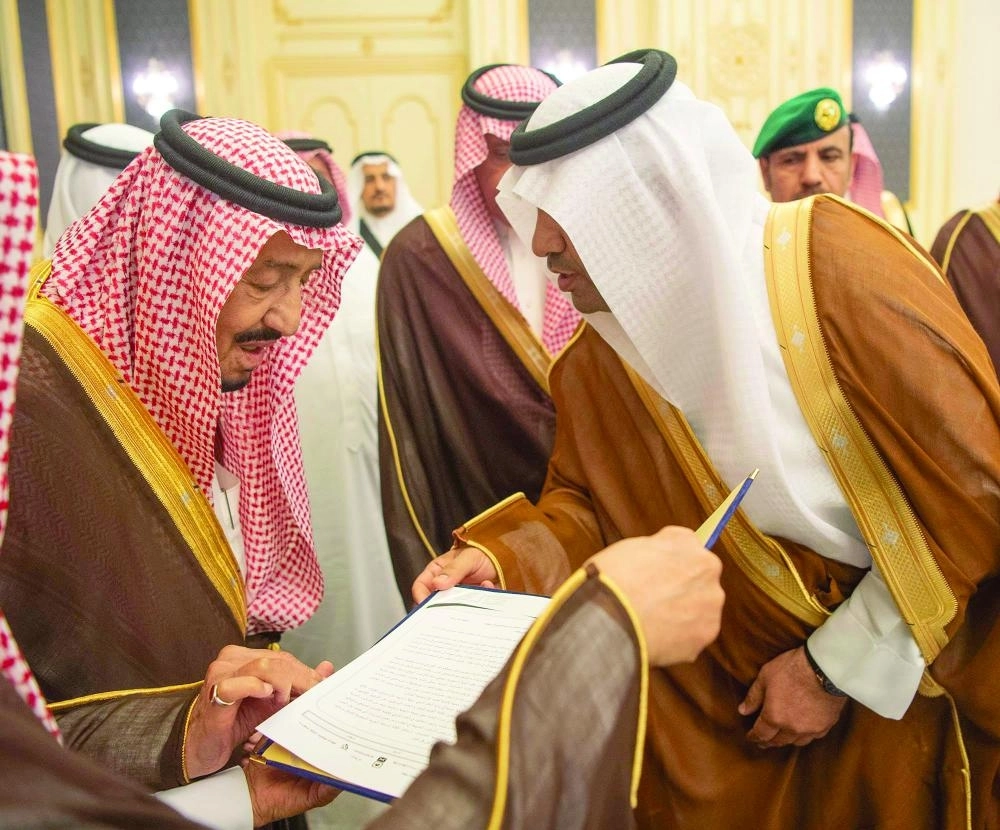 خادم الحرمين مطلعا على أحد التقارير خلال الاستقبال (واس)