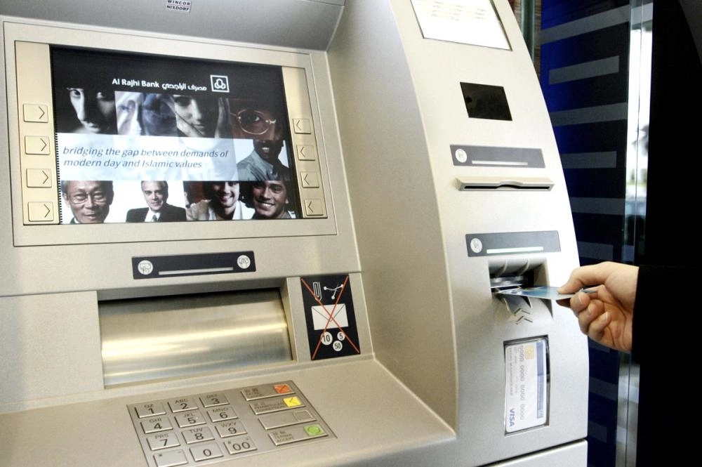 عميل يستخدم صرافا آليا لأحد البنوك               (مكة)