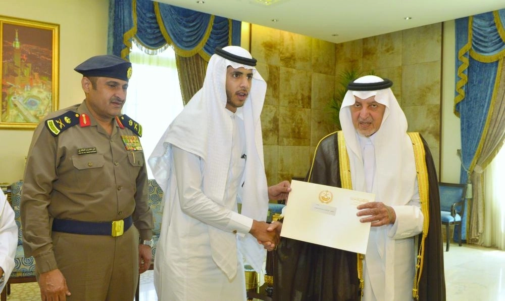 خالد الفيصل لدى تكريمه أحد الشباب   (مكة)