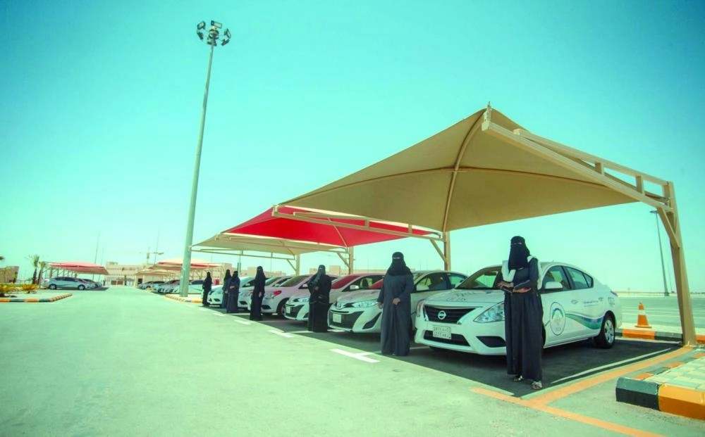 سيدات يقفن أمام المركبات في مدرسة جامعة القصيم لتعليم القيادة                                                                                       (واس)