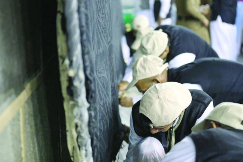 فريق العمل أثناء رفع ثوب الكعبة أمس  (مكة)