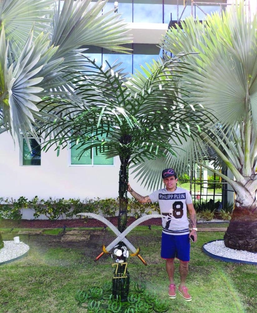 






إيلتون أمام منزله مع مجسم النخلة والسيفين